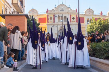 ALMERIA, İSPAN - Nisan 05, 2023 Kutsal Hafta 'da insanların geçit töreni. Törene katılan sakinler üzerinde azizlerin resimleri olan platformlar giyerler.