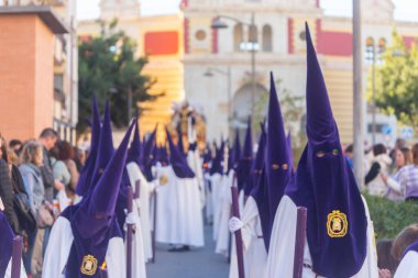 ALMERIA, İSPAN - Nisan 05, 2023 Kutsal Hafta 'da insanların geçit töreni. Törene katılan sakinler üzerinde azizlerin resimleri olan platformlar giyerler.