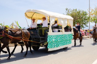 NERJA, SPAIN - 15 Mayıs 2022 Şehir sakinleri, arabalar, arabalar, atlar, öküzler ve traktörler, komşu köylerden gelen çiftçiler hepsi en iyi ve en güzel geleneksel halk kostümlerini giymişti.