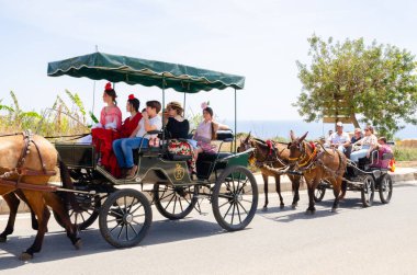NERJA, SPAIN - 15 Mayıs 2022 Şehir sakinleri, arabalar, arabalar, atlar, öküzler ve traktörler, komşu köylerden gelen çiftçiler hepsi en iyi ve en güzel geleneksel halk kostümlerini giymişti.