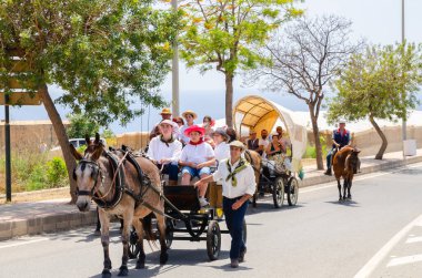 NERJA, SPAIN - 15 Mayıs 2022 Şehir sakinleri, arabalar, arabalar, atlar, öküzler ve traktörler, komşu köylerden gelen çiftçiler hepsi en iyi ve en güzel geleneksel halk kostümlerini giymişti.
