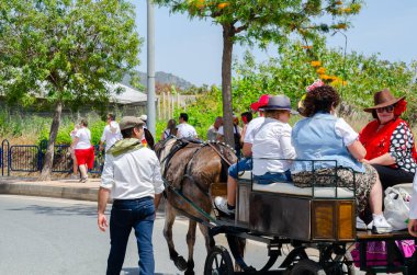NERJA, SPAIN - 15 Mayıs 2022 Şehir sakinleri, arabalar, arabalar, atlar, öküzler ve traktörler, komşu köylerden gelen çiftçiler hepsi en iyi ve en güzel geleneksel halk kostümlerini giymişti.