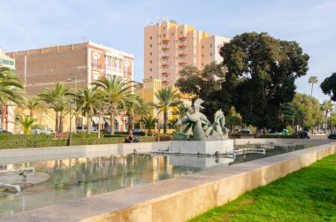 ALMERIA, İspanya - 11 Aralık 2023 Heykel, bir dikdörtgen çeşmenin ortasında yer alan ve dalgalarda oynayan beş güzel yunusu tasvir eder.