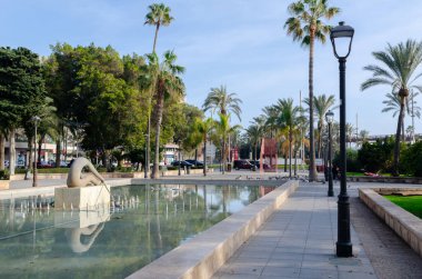 ALMERIA, İspanya - 11 Aralık 2023 Almerya, Endülüs, İspanya 'daki bir kamu parkında kürek çeken bir adamın heykelini resmeden bir çeşme