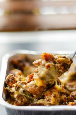 Üzerine olgun çedar peyniri ve Monterey Jack peyniri, jalapeno ve pastırma sosu ile kaplanmış kızarmış patates kızartması, mozzarella ve maydanozla birlikte, kirli patates kızartması.