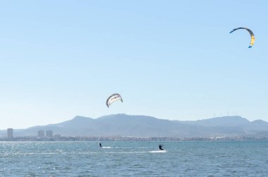 LA MANGA, İspanya - 27 Şubat 2019 İspanya 'nın La Manga kentindeki sığ bir gölde uçurtma sporu yapan insanlar