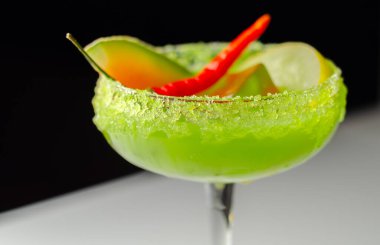 Votka, likör, taze kavun ve kırmızı kuş gözü biberi üzerine kurulu bir bayram kokteyli. Bir barmenin hazırladığı ferahlatıcı bir içecek.