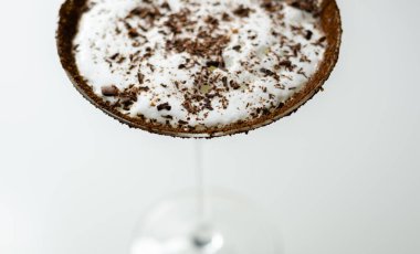 Bir martini bardağına bir çikolata martini dökülür. İçkinin üstünde çikolata garnitür var.