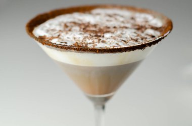 Bir martini bardağına bir çikolata martini dökülür. İçkinin üstünde çikolata garnitür var.