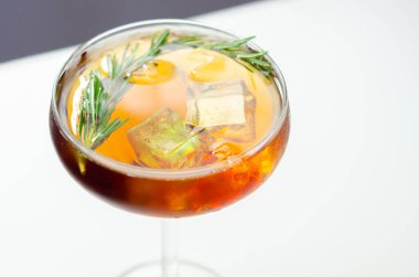 Üstünde biberiye ve karışık içecek olan bir bardak kokteyl.