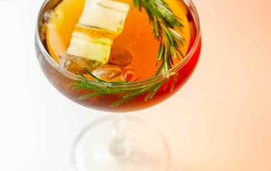 Üstünde biberiye ve karışık içecek olan bir bardak kokteyl.