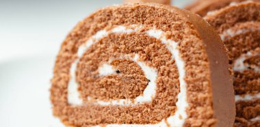 Beyaz kremalı bir dilim çikolatalı pasta. Pasta kesilmiş ve sarmal bir şekle sahip.