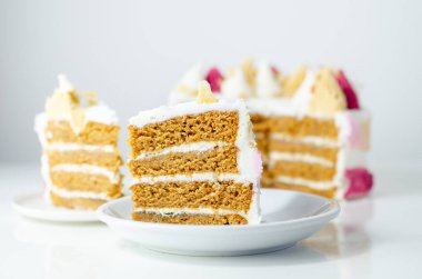 Üstünde pembe, sarı ve beyaz krema olan bir dilim pasta. Pasta katmanlar halinde kesilmiş ve üzerinde pembe beyaz krema var.