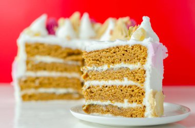 Üstünde pembe, sarı ve beyaz krema olan bir dilim pasta. Pasta katmanlar halinde kesilmiş ve üzerinde pembe beyaz krema var.