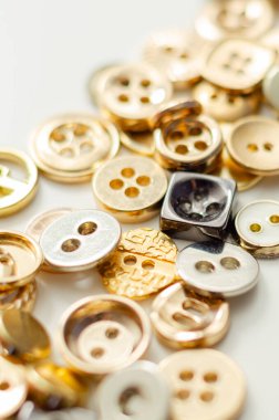 Çeşitli şekil ve boyutlarda bir yığın düğme. Düğmeler görüntüye dağılmış, bazıları birbiriyle örtüşüyor. Bolluk ve çeşitlilik kavramı