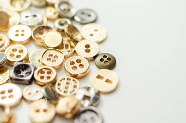 Çeşitli şekil ve boyutlarda bir yığın düğme. Düğmeler görüntüye dağılmış, bazıları birbiriyle örtüşüyor. Bolluk ve çeşitlilik kavramı