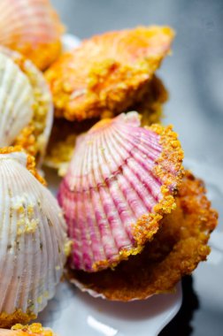 Üzerinde kabuk olan bir tabak yemek. Kabuklar pembe ve beyaz. Plakası siyah arka planda.