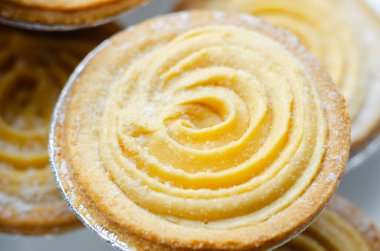 Tepesinde krema olan bir hamur işi. Şekerleme pudra şekerinden yapılmış ve spiral bir desen içinde yayılmış.