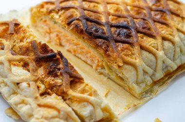 İçinde somon olan bir parça hamur işi kesilir. Hamur işi kahverengi ve çıtır çıtır bir dokusu var.