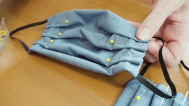 Koronavirüs salgını için dikiş makinesiyle pamuk yüz maskesi dikiyorum..