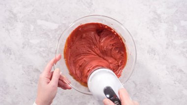 Düz yatıyordu. Adım adım. Kırmızı kadife kek hazırlamak için karıştırma kabındaki malzemeleri karıştırıyorum..