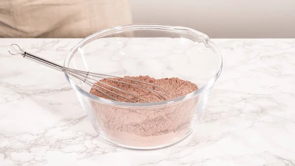 stock image Step by step. Mixing ingredients in a glass mixing bowl to bake a chocolate cupcake.