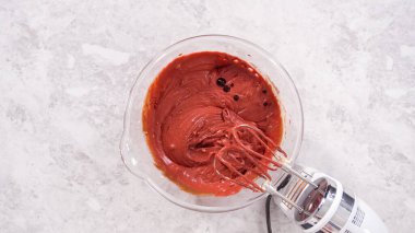 Düz yatıyordu. Adım adım. Kırmızı kadife kek hazırlamak için karıştırma kabındaki malzemeleri karıştırıyorum..