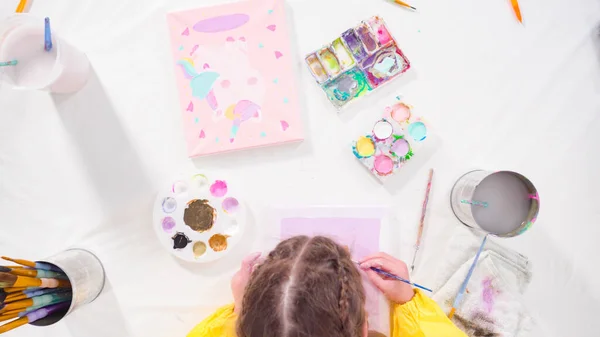 stock image Flat lay. Little girl painting with acrylic paint on canvas with her mother for a distant learning art project.