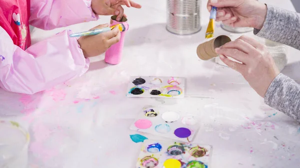 stock image Kids papercraft. Painting empty toilet paper rolls with acrylic paint to create paper bugs.