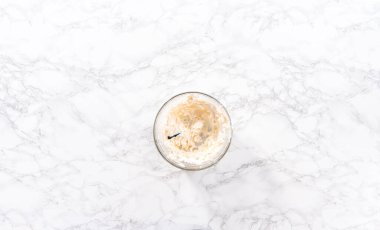 Düz yatıyordu. Marketten alınmış tereyağlı kremanın karışımı bardakta karıştırılıyor..