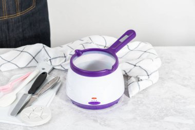 Çikolata parçacıkları eriyor elektrikli şeker tenceresinde.