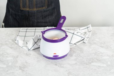 Çikolata parçacıkları eriyor elektrikli şeker tenceresinde.