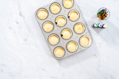 Düz yatıyordu. Mardi Gras vanilyalı kek pişirmek için folyolu kek dilimli vanilyalı kek hamuru..