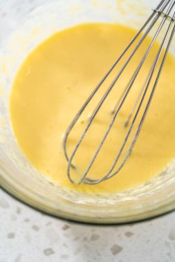 Islak malzemeleri küçük bir bardakta karıştırıp kek pişirmek için karıştırıyorum..