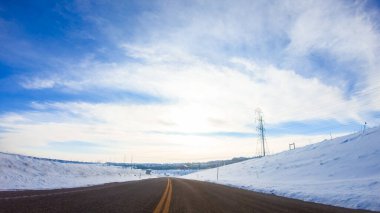 Kış sabahı Amerikan banliyölerinde kırsal bir yolda araba sürerken.