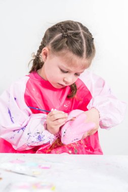 COVID-19 tecridi sırasında evde eğitim. Kağıt mache boyalı küçük kız Akrilik boyalı Paskalya tavşanı biblosu.