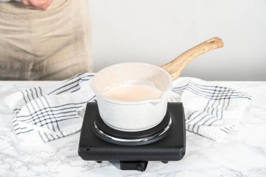 Preparing chocolate ganache in a small saucepan.