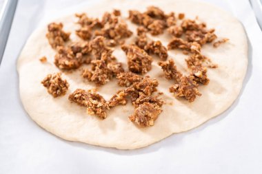 Parşömen kağıdıyla kaplı bir kabın üzerinde tarçınlı tatlı pizzası hazırlıyorum..