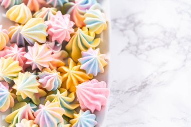 Beyaz servis tabağında çok renkli tek boynuzlu at kurabiyeleri..