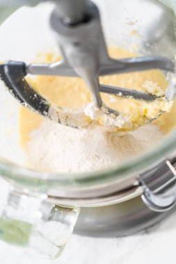 Mixing ingredients in kitchen electric mixer to bake American flag mini cupcakes.