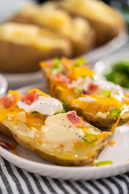 Fırında pişmiş patates. Tereyağı, ekşi krema, peynir ve pastırma parçalarıyla süslenmiş büyük fırında patates..