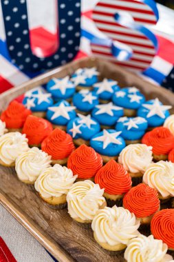 Arranging mini vanilla cupcakes in the shape of the American flag.