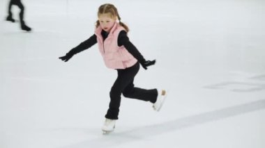 Küçük patenci sabah artistik patinaj antrenmanında elementlerini çalışıyor..