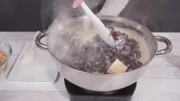 時間の経過 一歩ずつ マカダミアナッツファッジを作るために調理鍋にチョコレートチップを溶かす — ストック動画