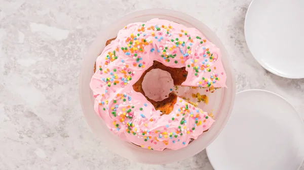 Leżeć Płasko Krok Kroku Krojenie Funfettti Bundt Ciasto Różowym Lukrem — Zdjęcie stockowe