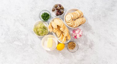 Düz yatıyordu. Tereyağı tahtasını sebze ve ekmekle karıştırmak için cam kaselerde ölçülmüş malzemeler..