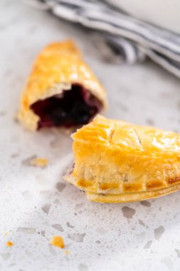 Mutfak tezgahında yaban mersinli taze pişmiş tatlı börekler..