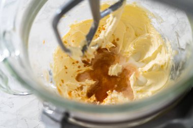 Mutfaktaki elektrikli mikserin içeriğini karıştırıp tereyağlı krema yapıyorum..