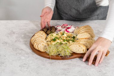 Sebzeli tereyağı tahtası ve tahta kesme tahtasında ekmek..