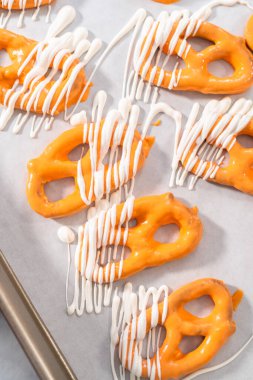 Çikolata soslu krakerlerin üzerine erimiş çikolata serpiştirmek..